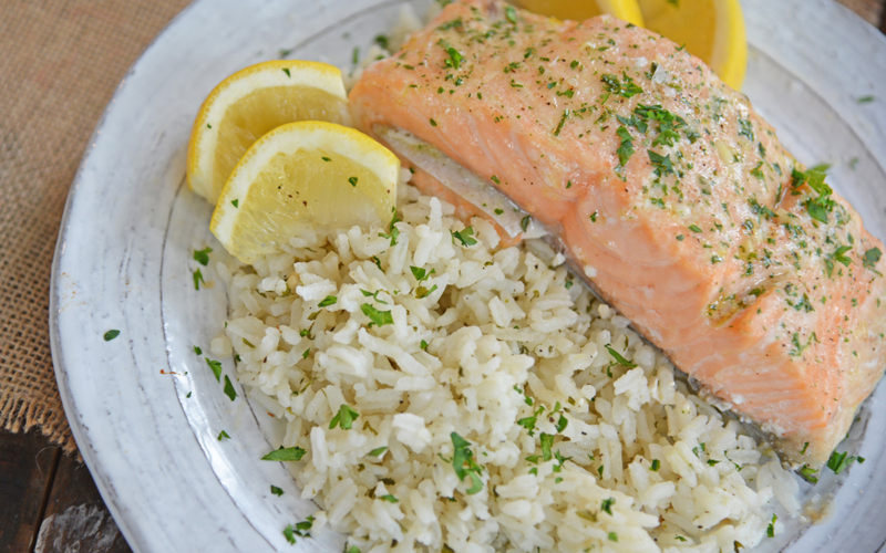 Ranch rice on a plate with lemons and salmon