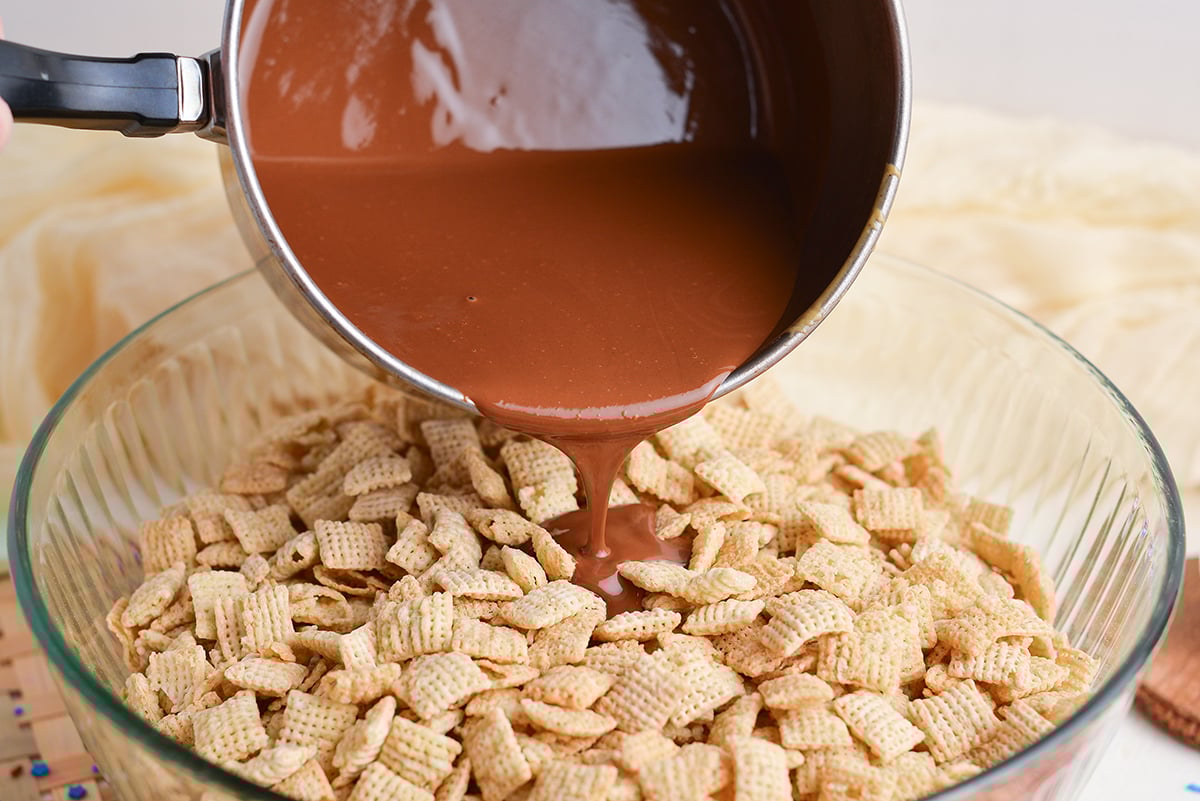 melted chocolate pouring into bowl of chex cereal