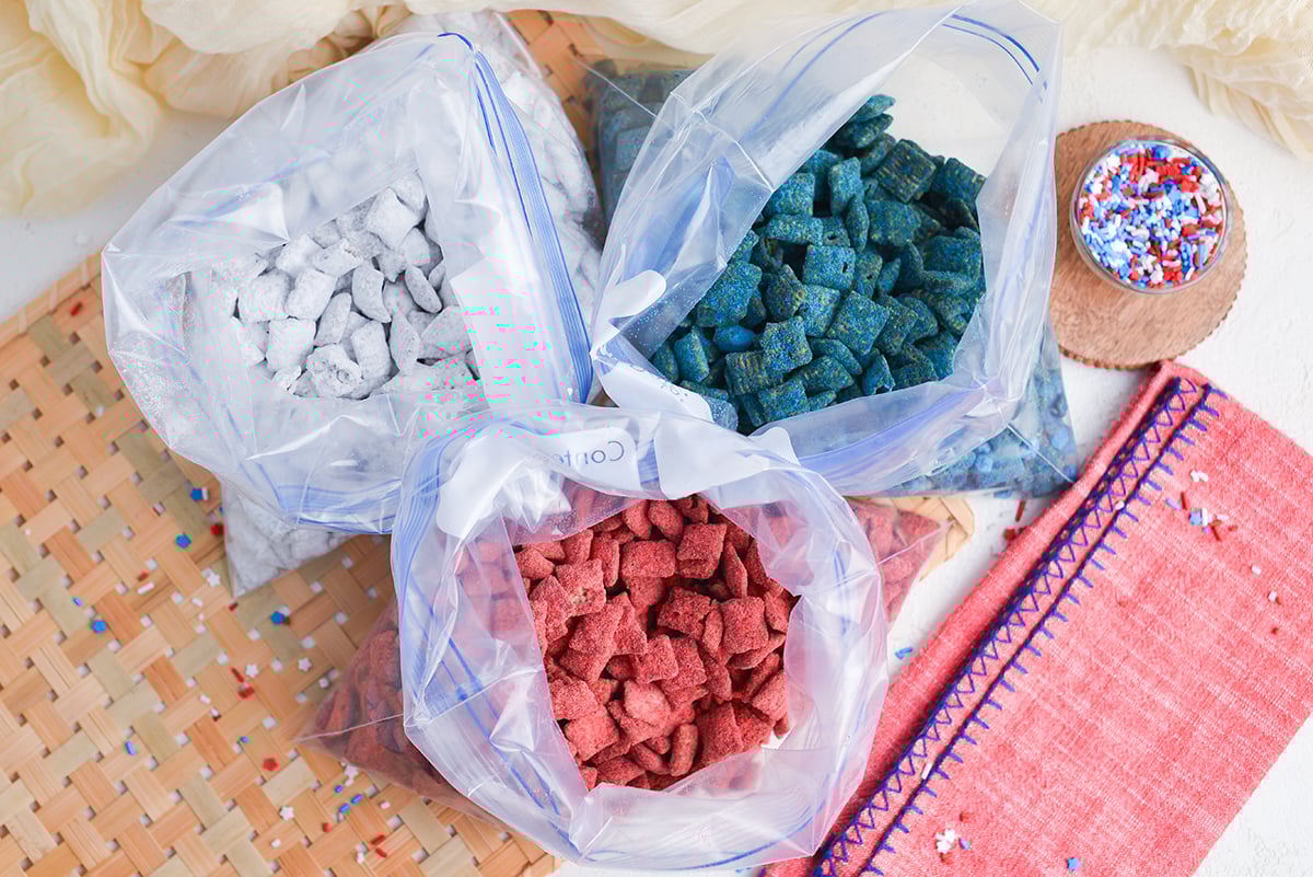 overhead shot of three Ziplock bags filled with red white and blue puppy chow
