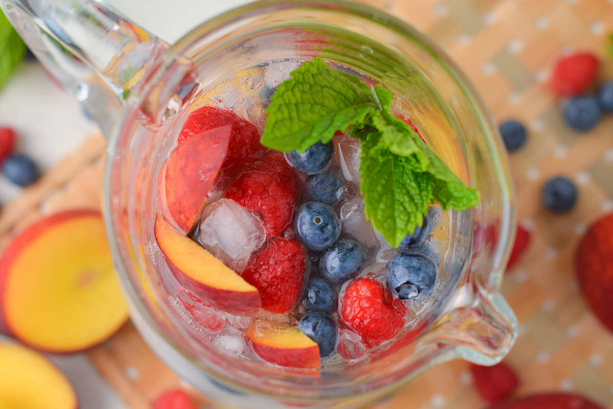 close up overhead shot of sparkling peach sangria in pitcher