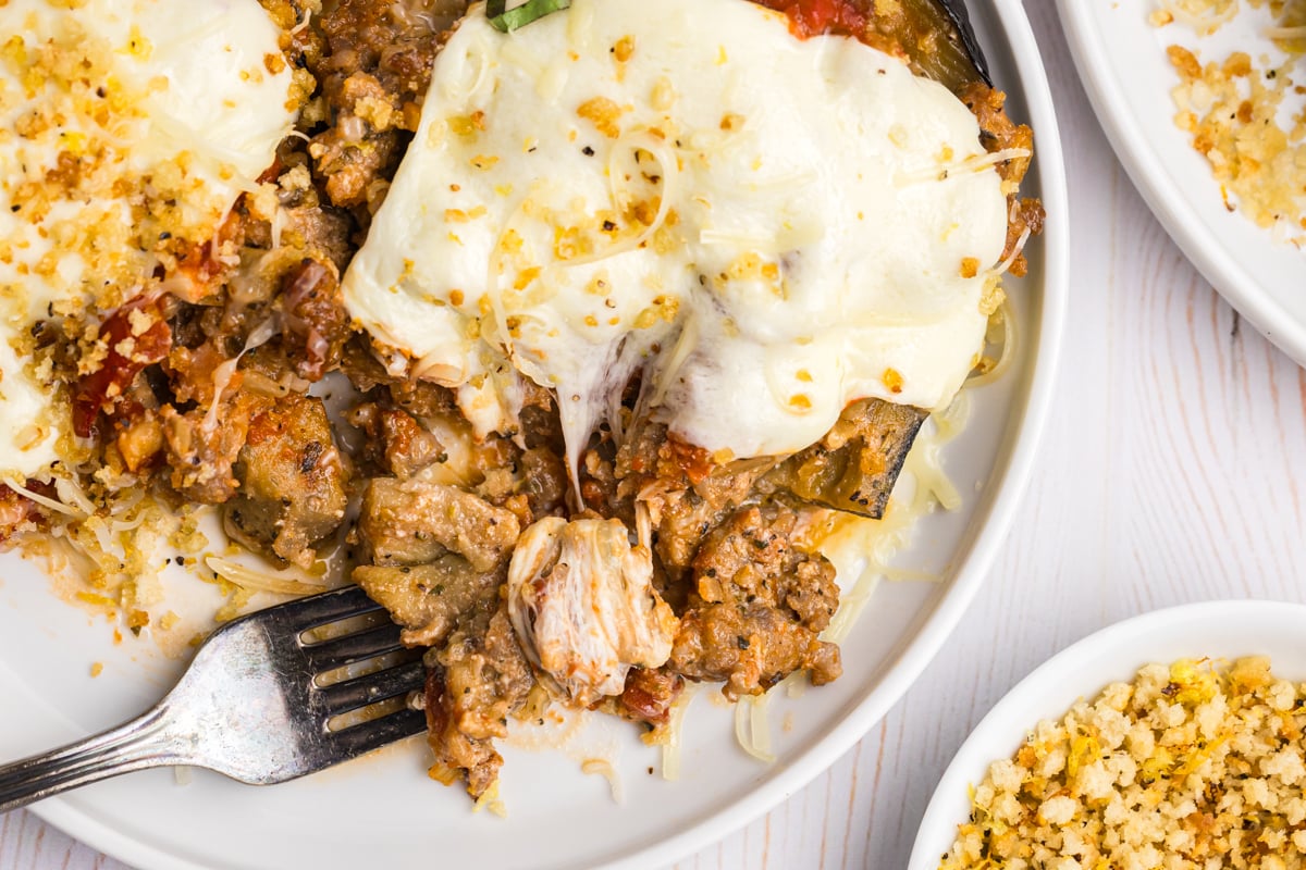 overhead shot of fork taking bite from stuffed eggplant