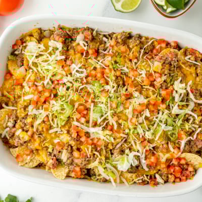 overhead shot of taco bake casserole in dish topped with lettuce