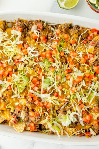 overhead shot of taco bake casserole in dish topped with lettuce