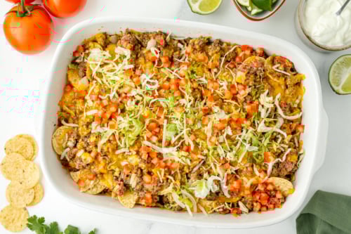 overhead shot of taco bake casserole in dish topped with lettuce