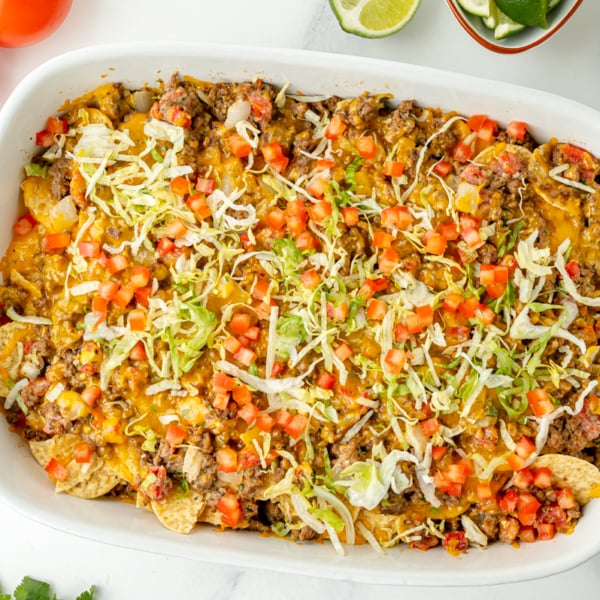 overhead shot of taco bake casserole in dish topped with lettuce
