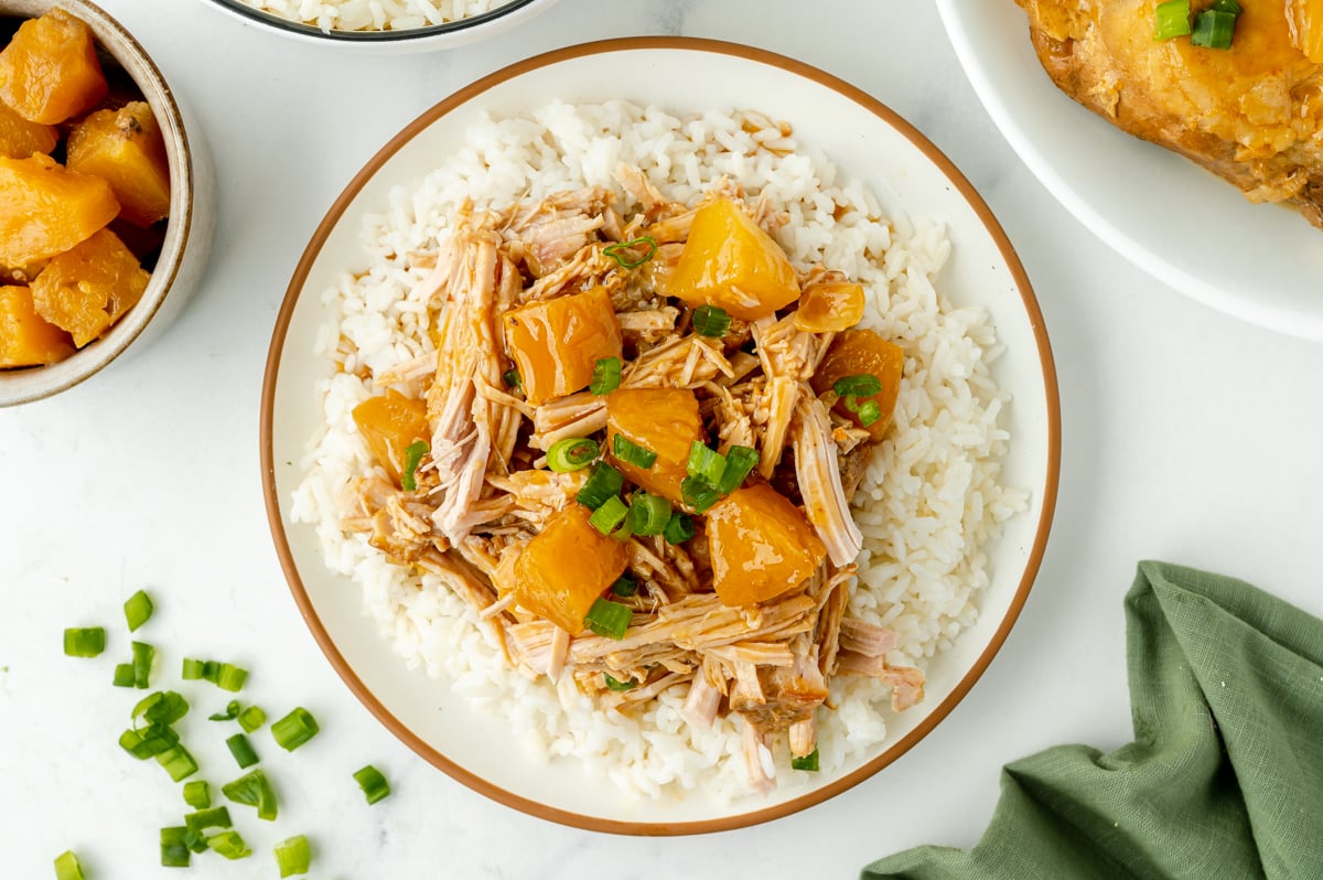 overhead shot of shredded hawaiian pork loin over rice on plate