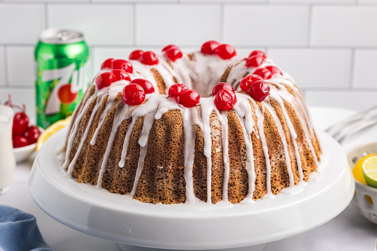 angled shot of pound cake on platter topped with cherries
