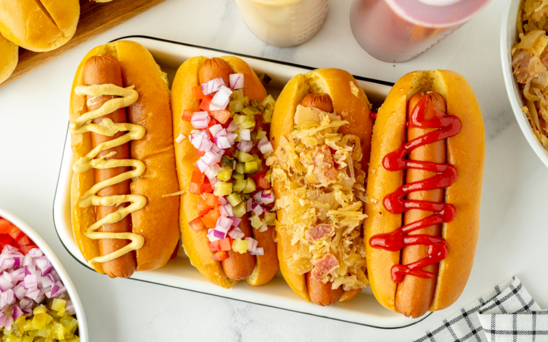 overhead shot of platter of hot dogs with different toppings