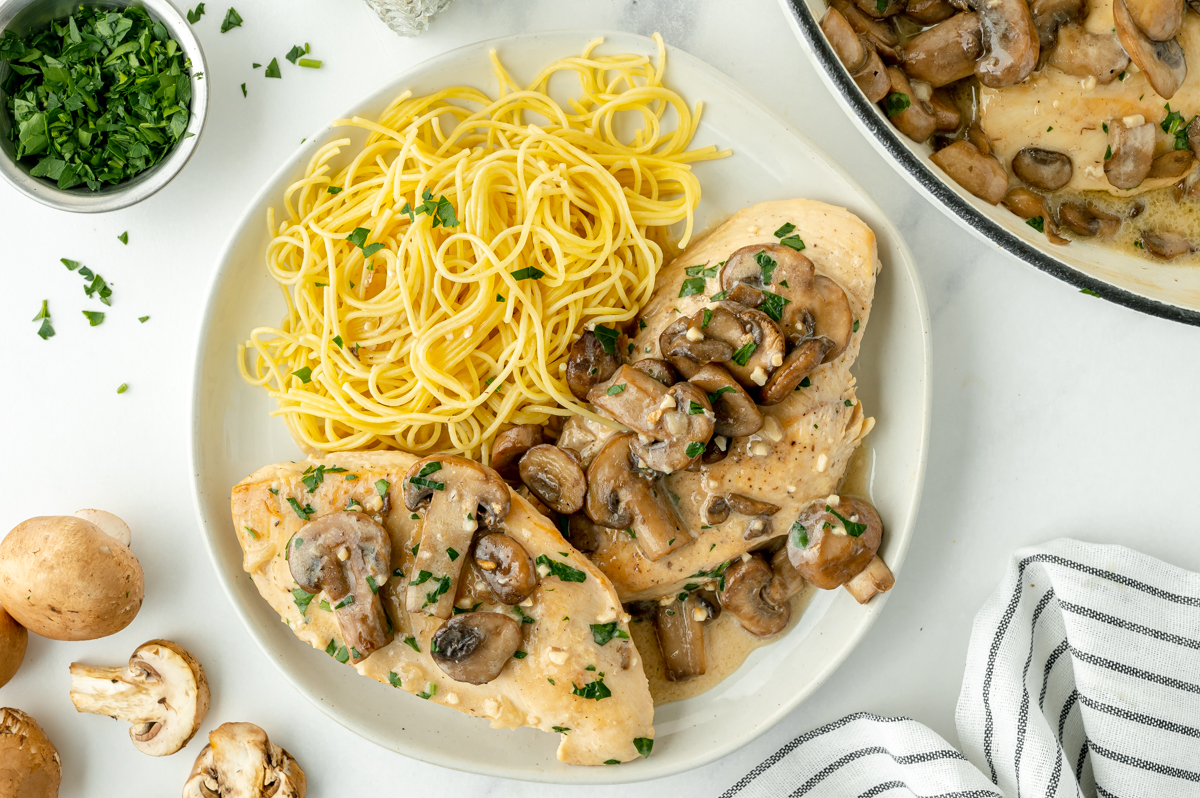 overhead shot of plate of chicken marsala on plate with pasta