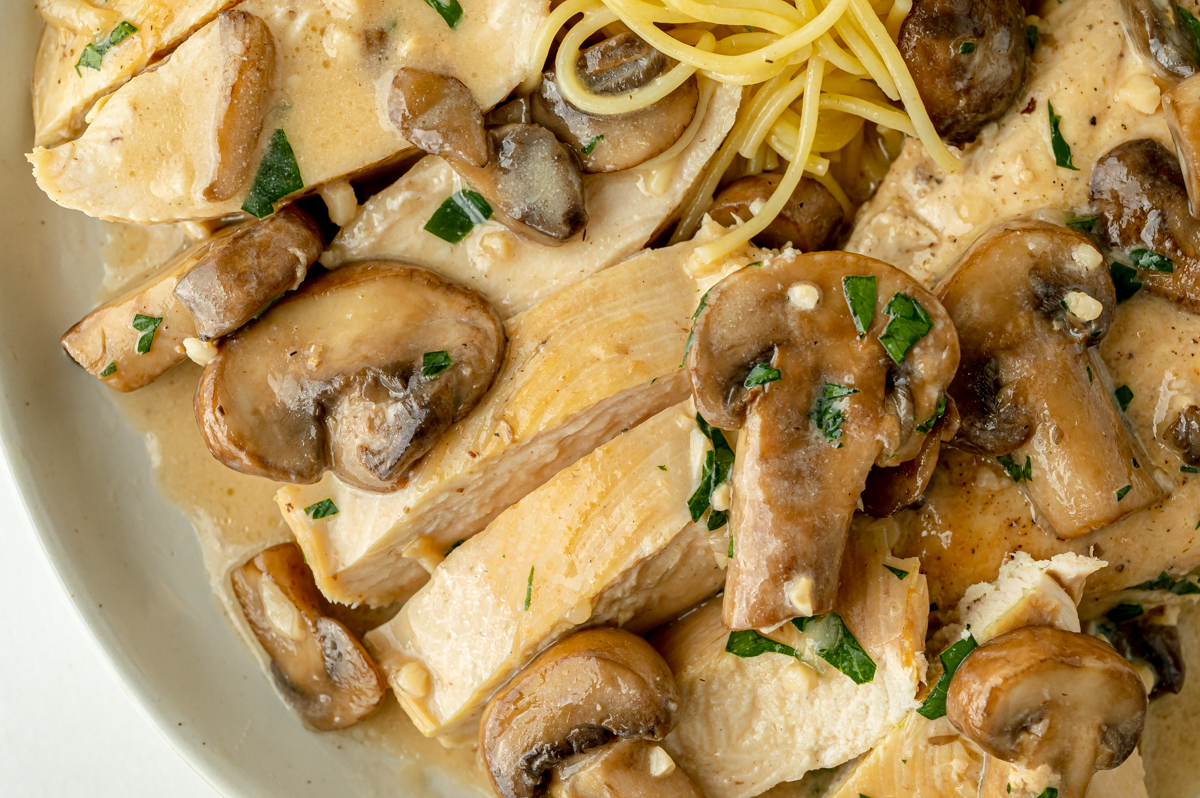 close up overhead shot of sliced chicken and mushrooms
