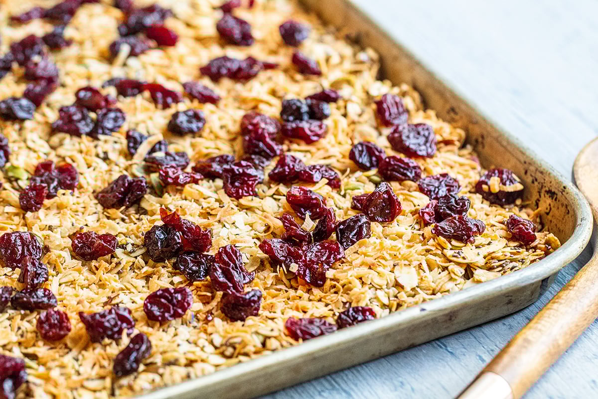 homemade granola before baking on a rimmed baking sheet