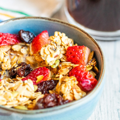 granola in a blue bowl with fresh berries