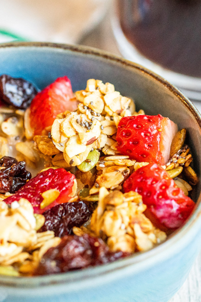 granola in a blue bowl with fresh berries