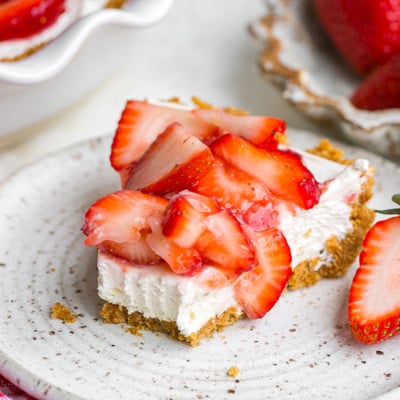bite taken out of slice of strawberry pie on plate