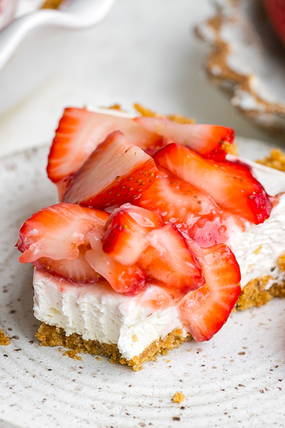 bite taken out of slice of strawberry pie on plate