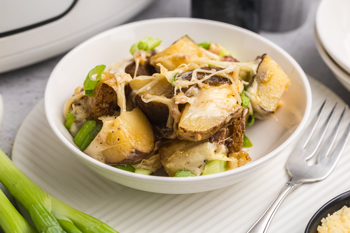angled shot of bowl of cheesy potatoes