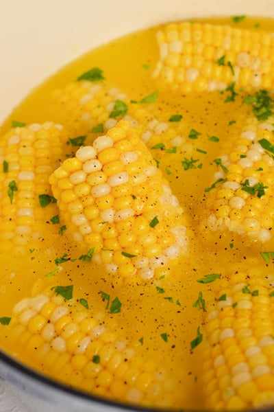 angled shot of boiling pot of corn on the cob