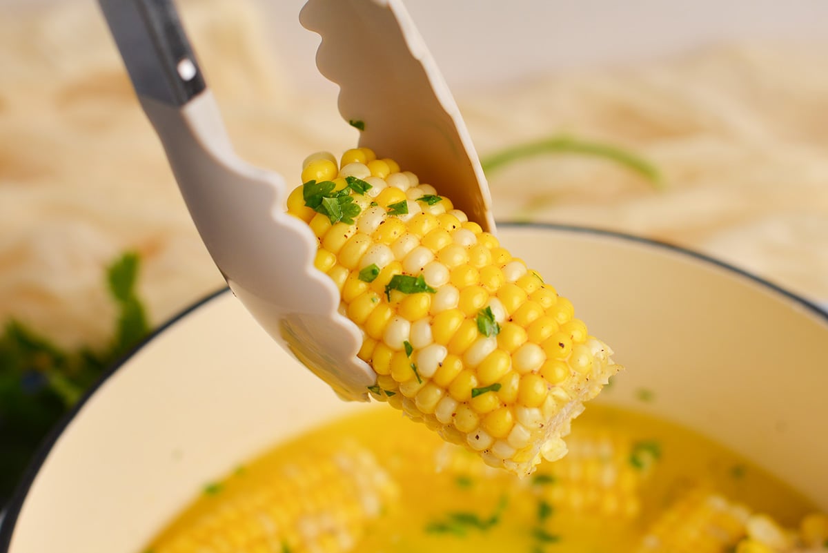 corn cob being held by tongs