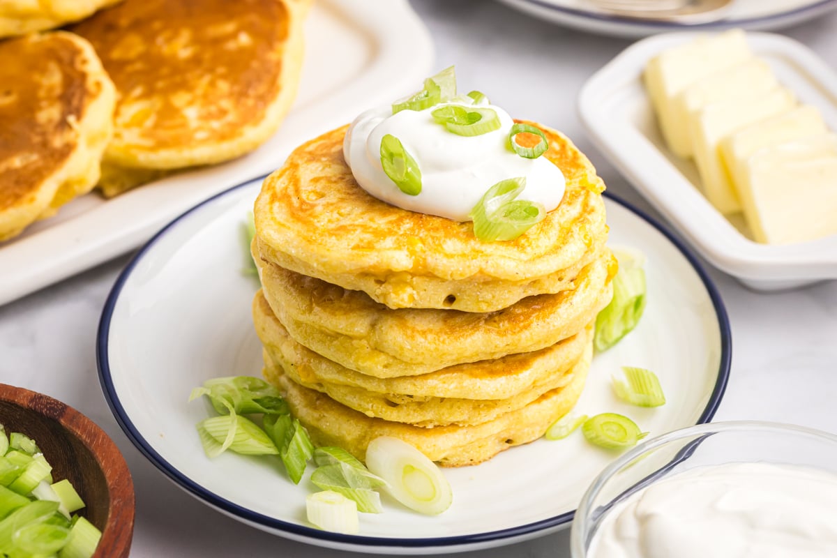 angled shot of corn cakes topped with sour cream and green onions
