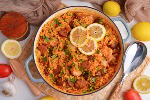 overhead shot of pan of shrimp paella with lemon slices