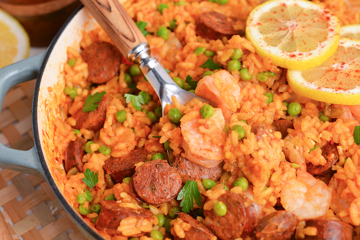 spoon in pan of shrimp and sausage paella