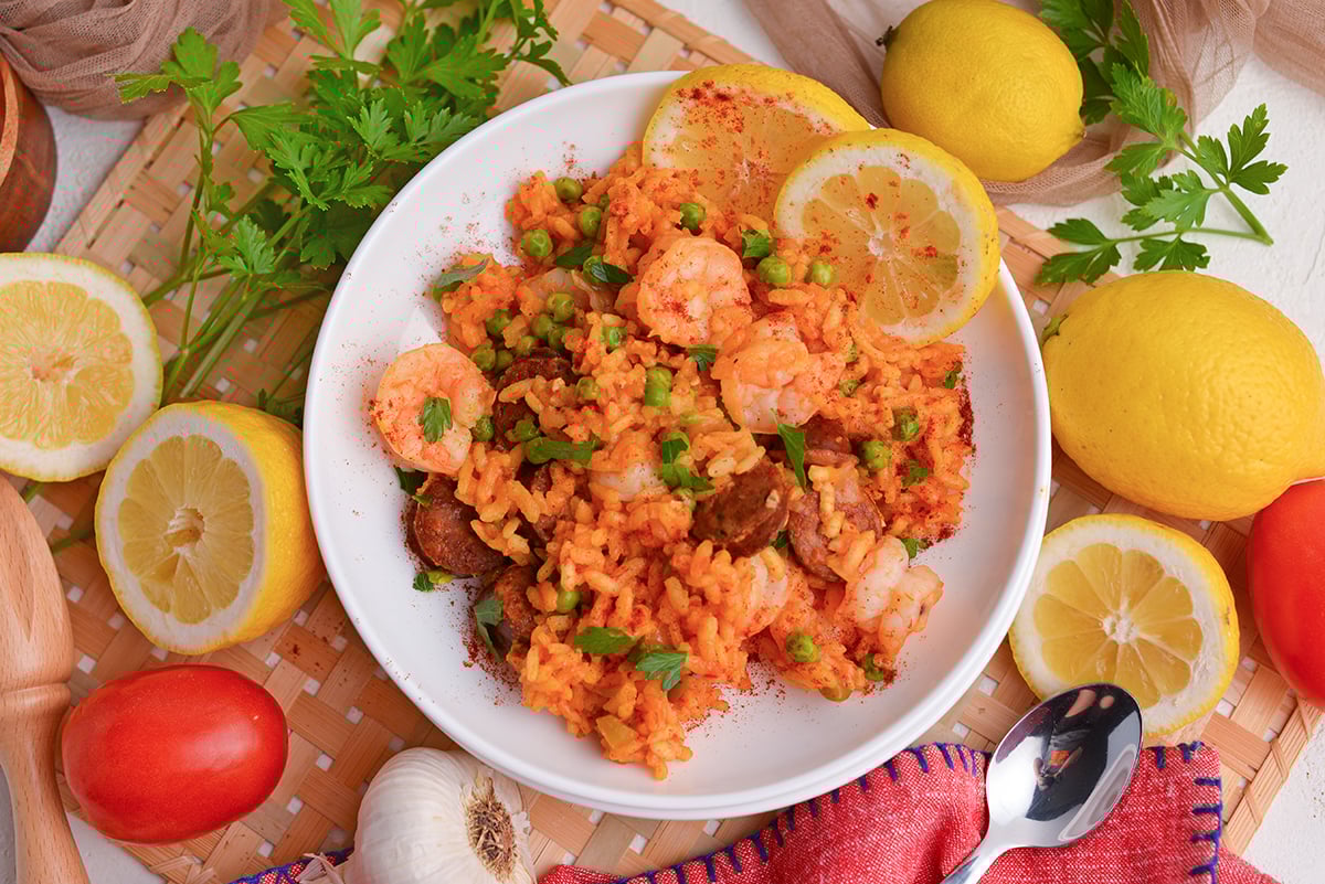 overhead shot of shrimp paella on plate with lemon slices
