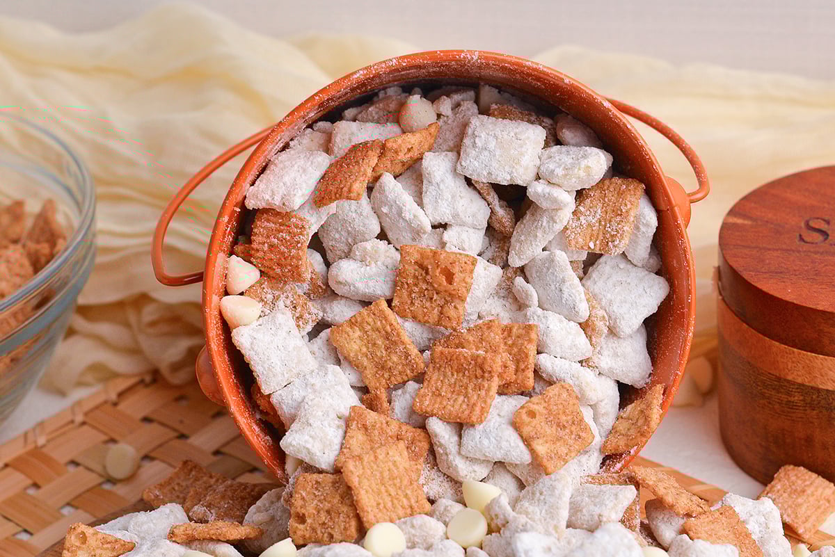 straight on shot of snickerdoodle puppy chow spilling out of bucket