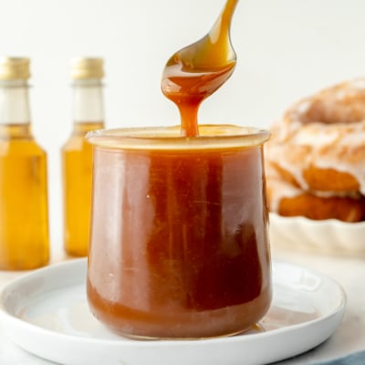 spoon dipping into jar of bourbon caramel sauce