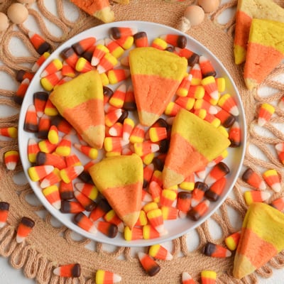 overhead shot of four candy corn cookies on plate of candy corn