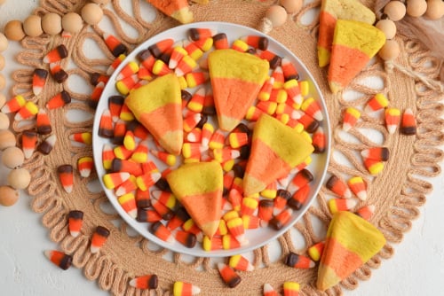 overhead shot of four candy corn cookies on plate of candy corn