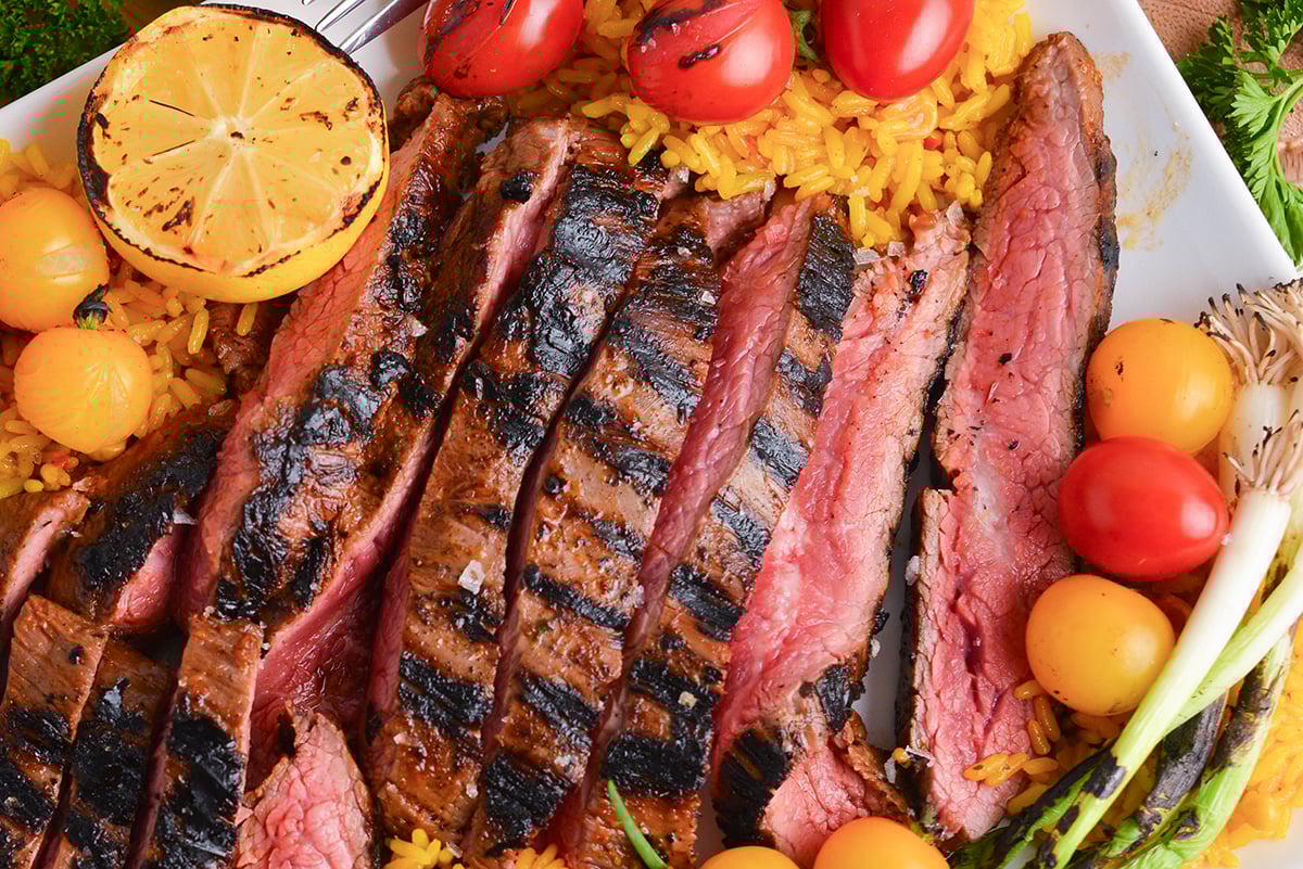 close up overhead shot of sliced steak on platter with rice
