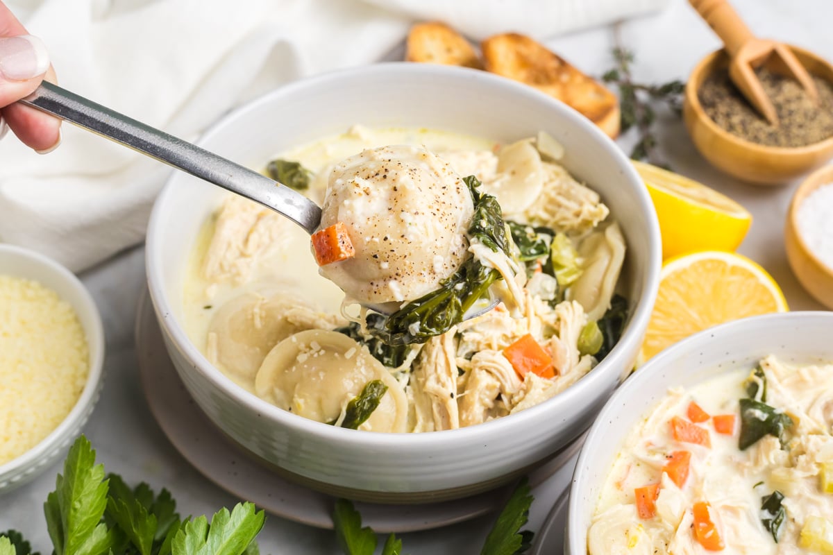 angled shot of bite of chicken florentine soup on spoon