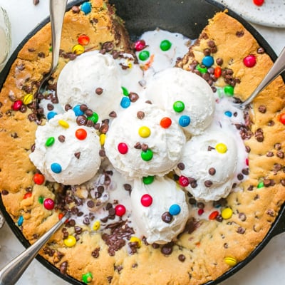 overhead shot of slice taken out of chocolate chip skillet cookie with ice cream