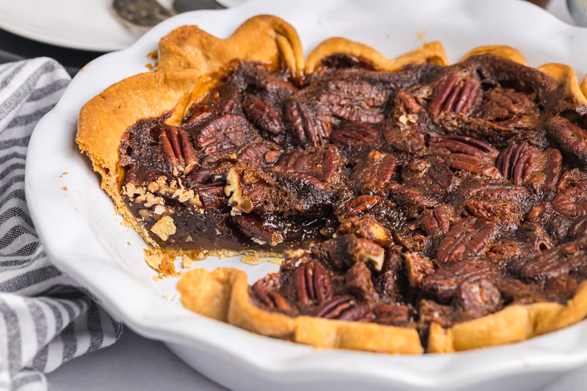 slice taken out of gooey chocolate pecan pie
