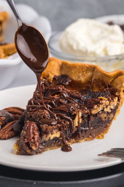 spoon drizzling melty chocolate over slice of pie