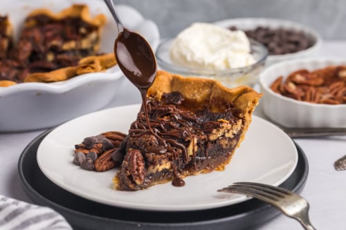 spoon drizzling melty chocolate over slice of pie