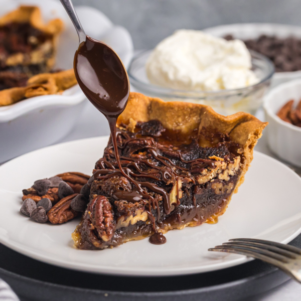 spoon drizzling melty chocolate over slice of pie