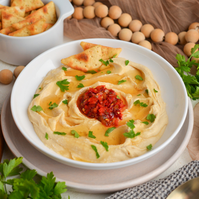 angled shot of bowl of hot honey hummus