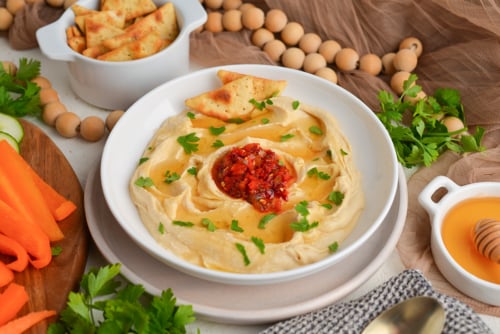 angled shot of bowl of hot honey hummus