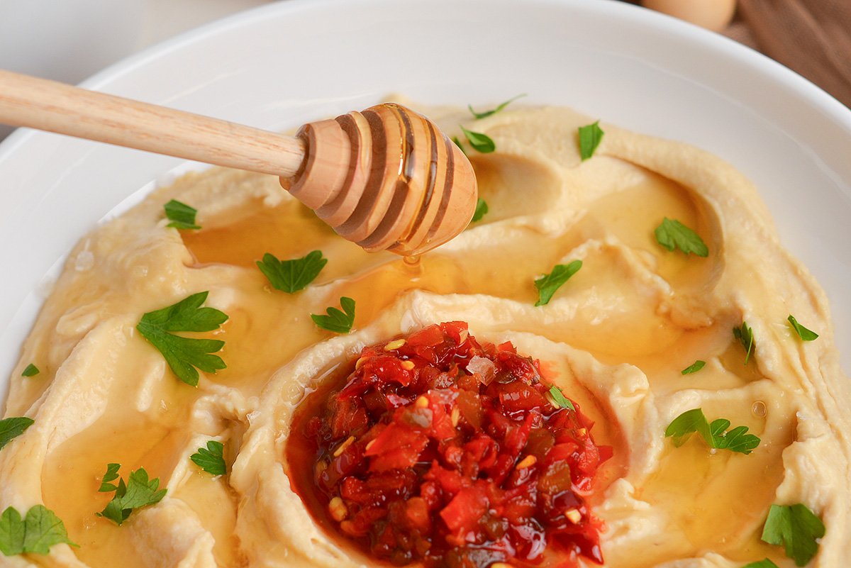 honey dripping onto bowl of hummus