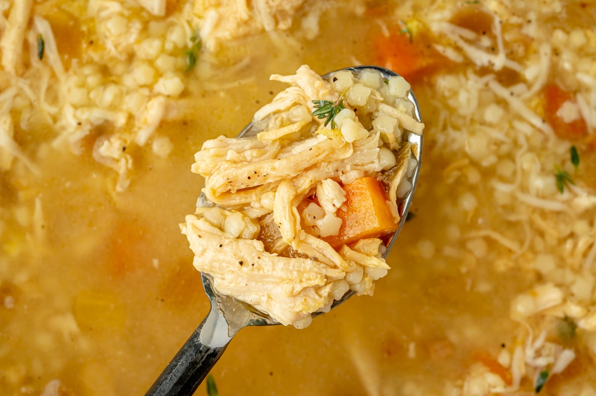 overhead shot of spoon full of italian pastina soup