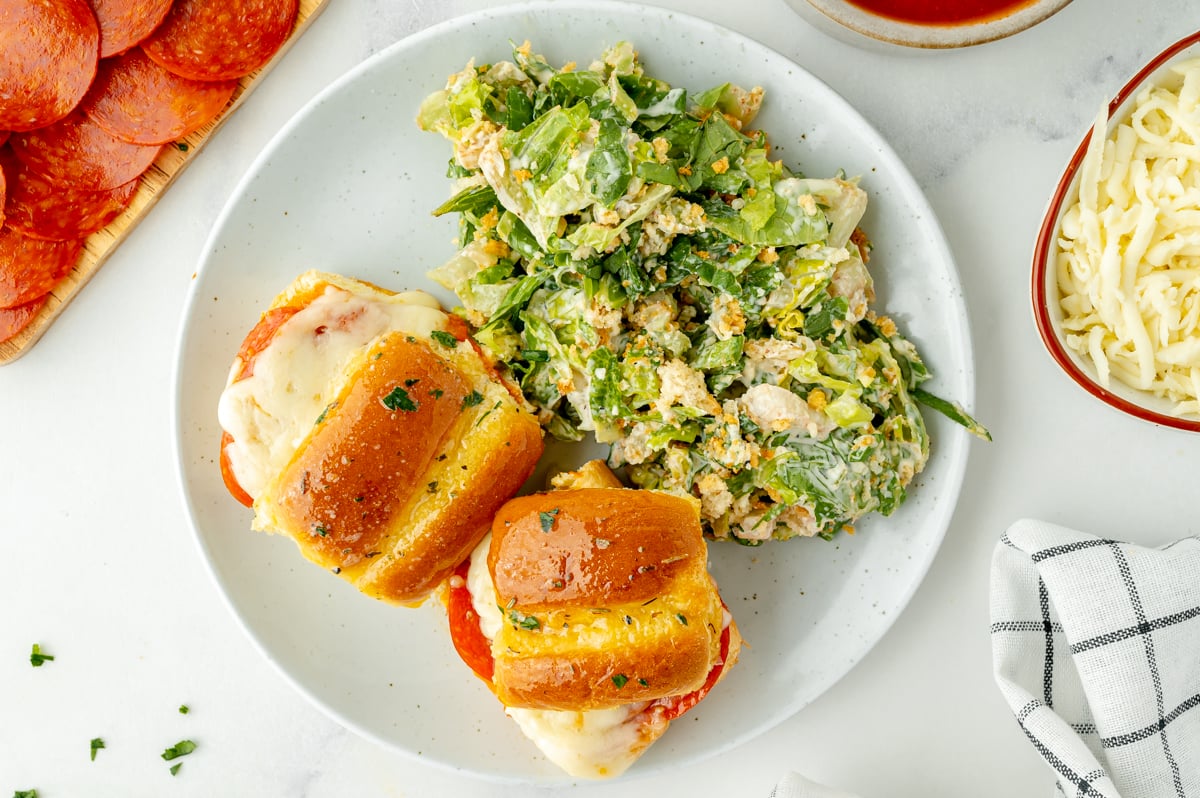 overhead shot of pizza sliders on plate with caesar salad