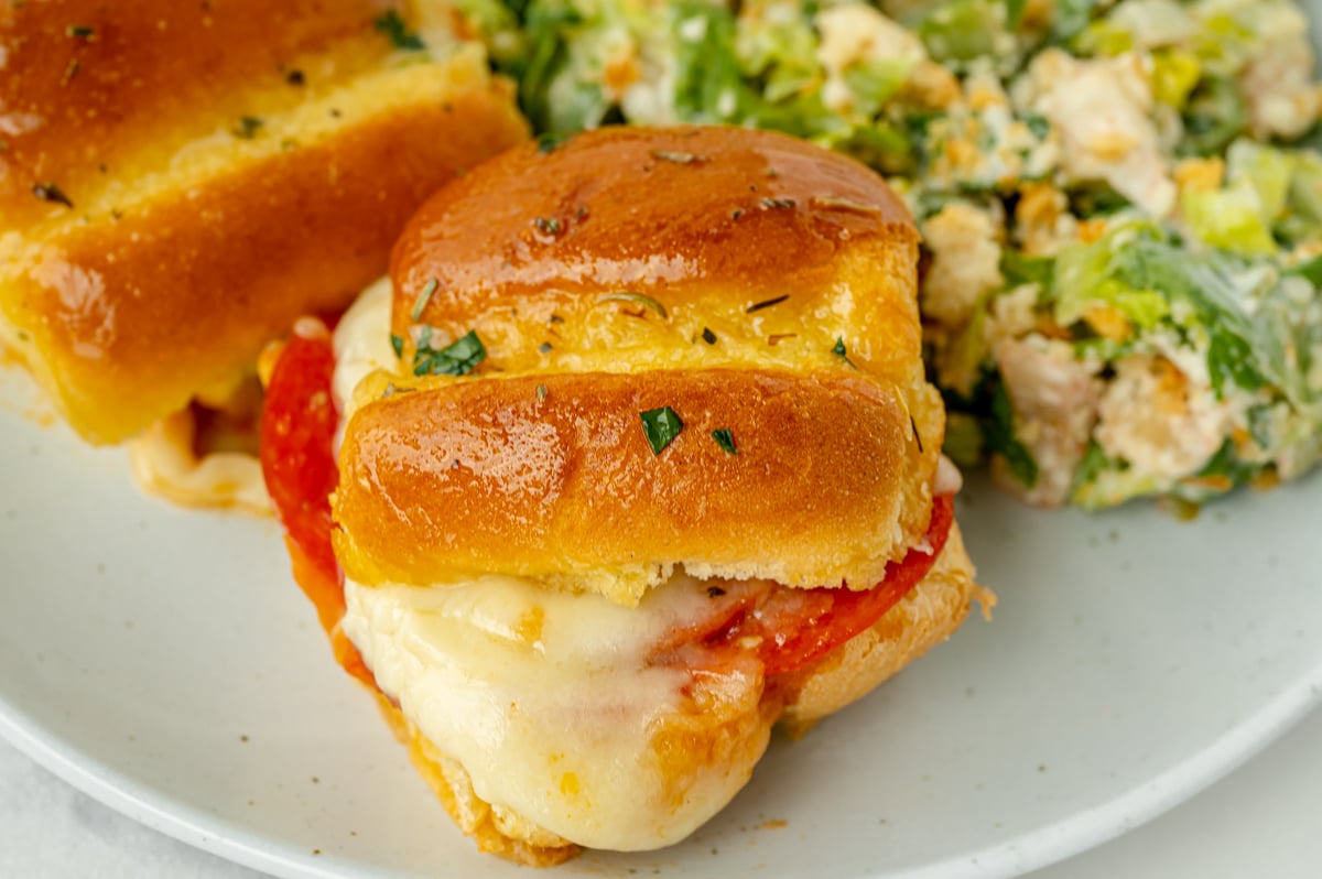 angled shot of pizza slider on plate with salad
