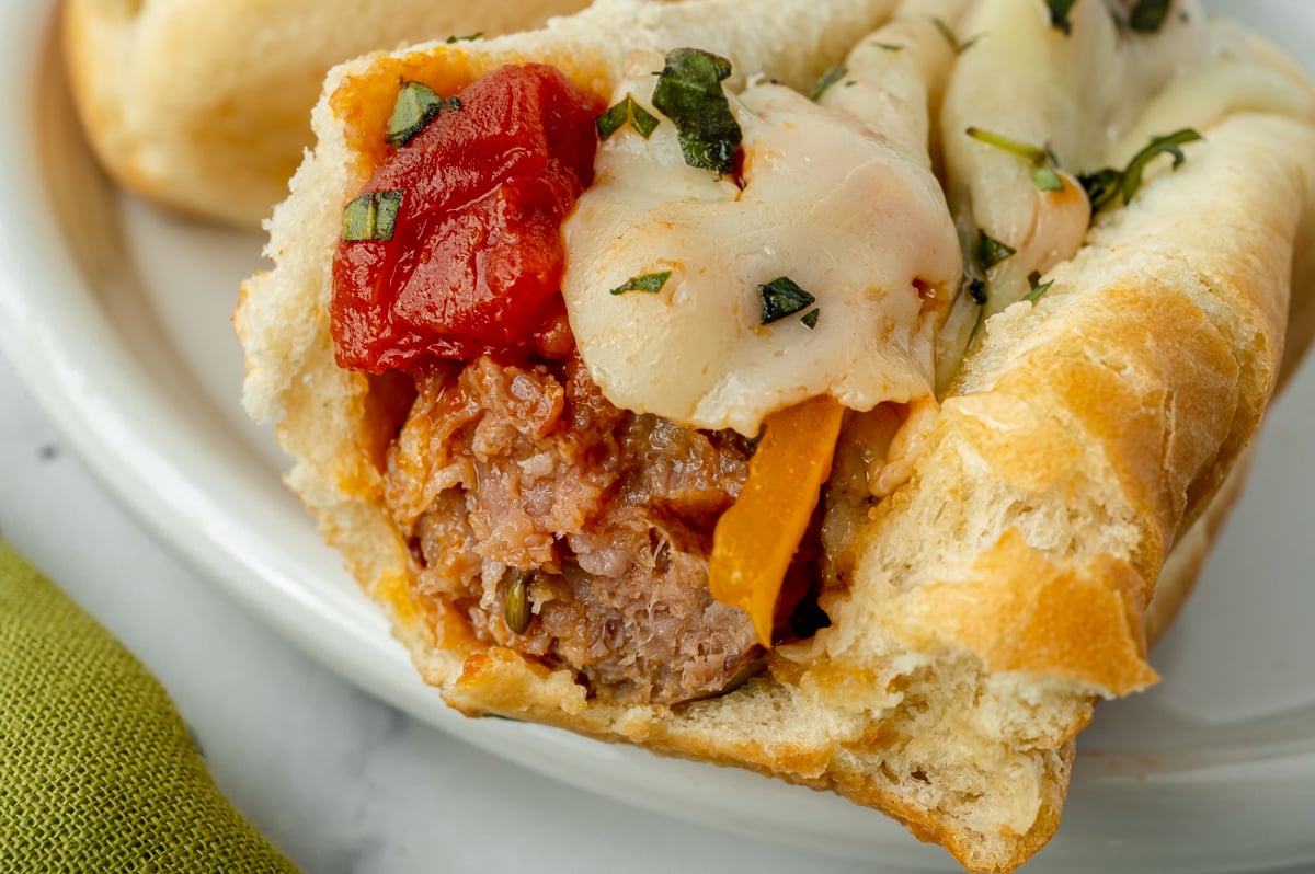 close up of bite taken out of sausage sandwich