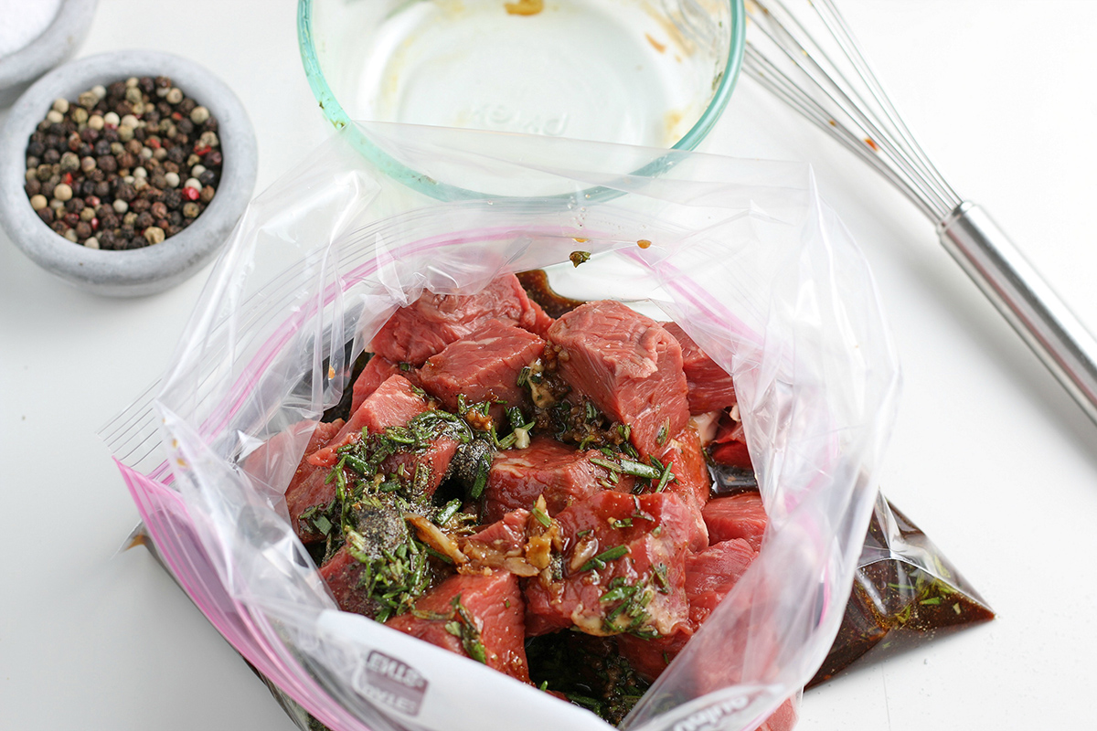 steak cubes in a plastic bag of steak kabob marinade
