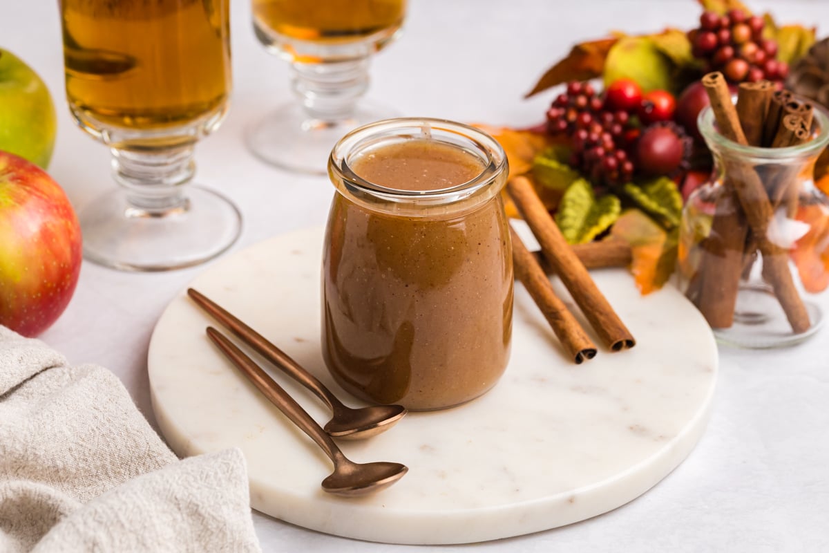 angled shot of jar of caramel with cinnamon sticks