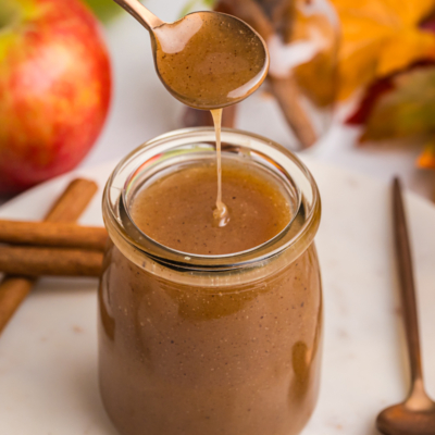 spoon dipping into jar of apple cider caramel sauce