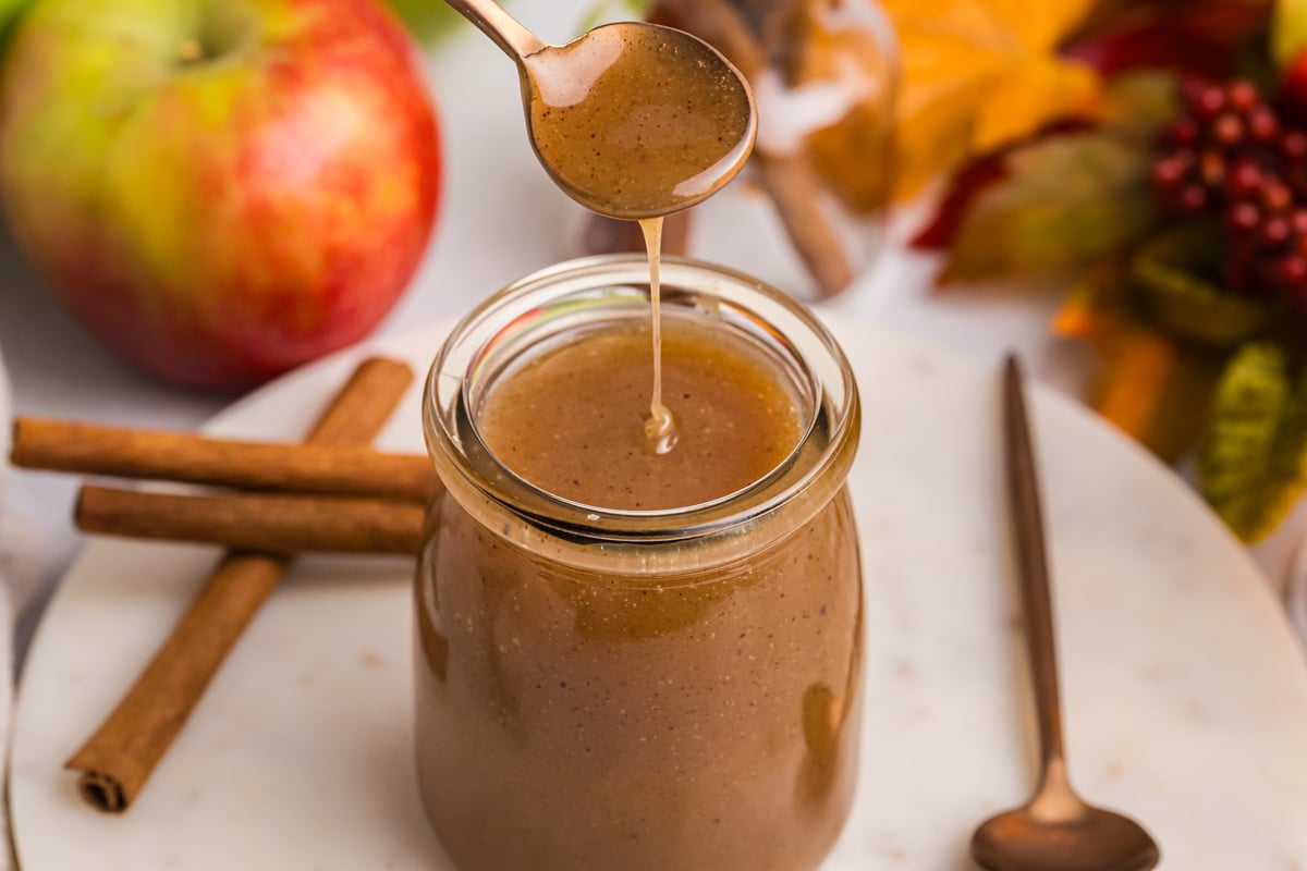 spoon dipping into jar of apple cider caramel sauce