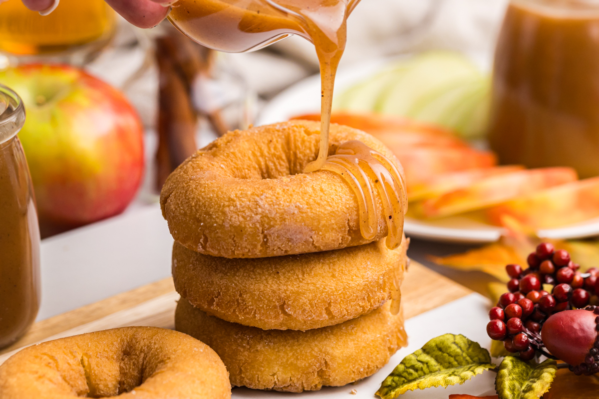 caramel sauce pouring over stack of donuts