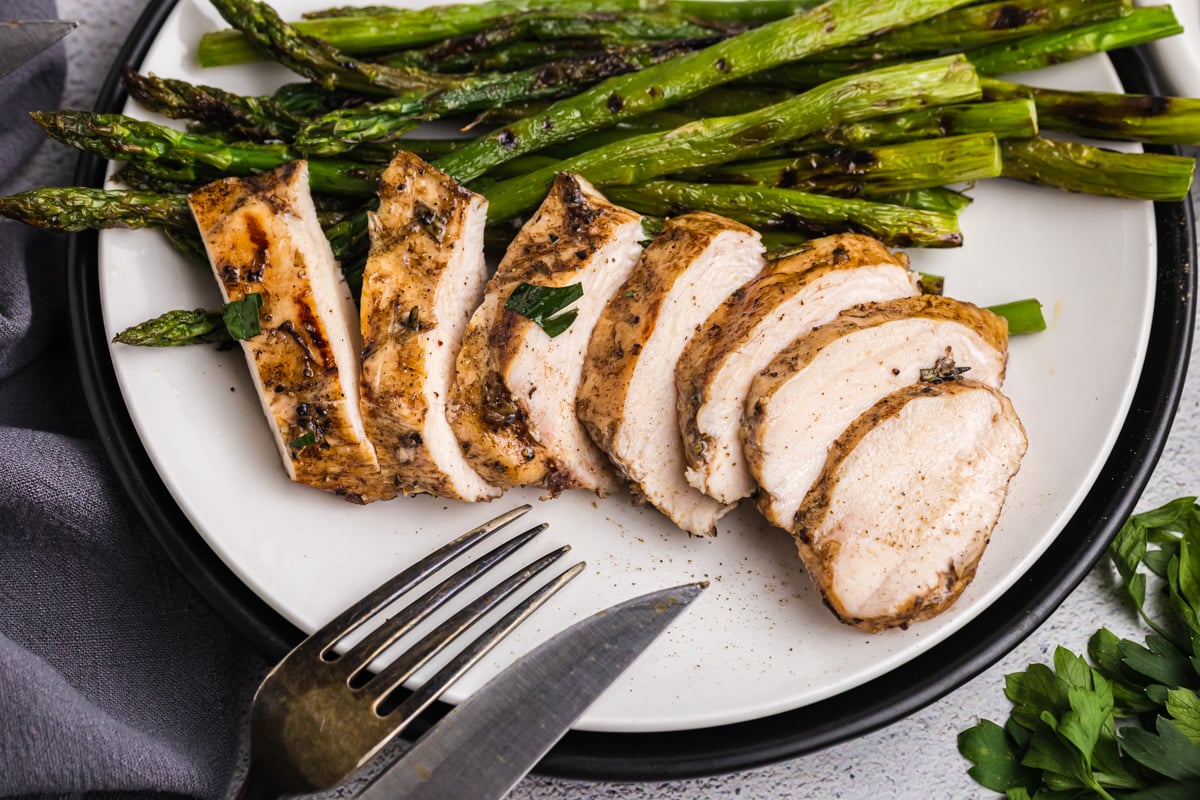 overhead shot of sliced chicken on plate with asparagus